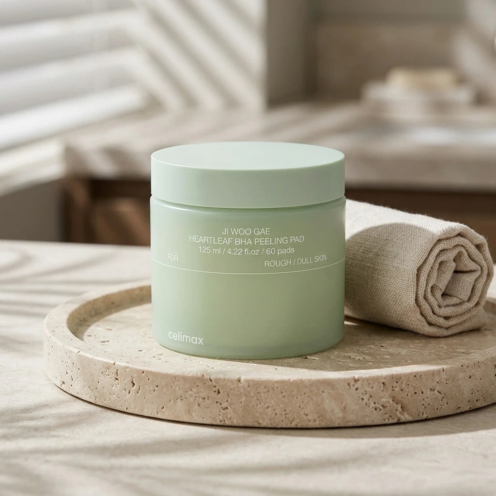 High-resolution commercial photo of Celimax Heartleaf BHA Peeling Pad jar arranged on a sleek beige travertine stone plate. Next to it, a delicate rolled linen towel. Soft, elegant window shadows cast across the scene, peaceful luxury spa atmosphere, realistic organic textures, editorial styling --ar 1:1 (gemini-3.1-flash-image-preview)