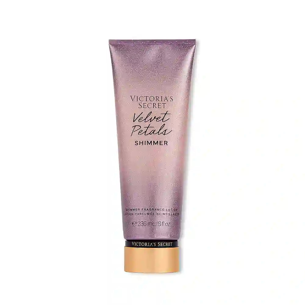 Victoria's Secret Velvet Petals Shimmer Lotion Parfumée bottle with floral design and golden accents, emitting a soft, luminous glow.