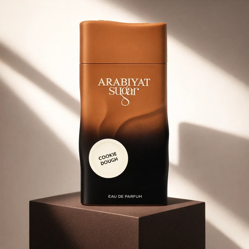 Bold, contemporary e-commerce product shot of the Arabiyat Sugar Cookie Dough perfume bottle (image_5207db.jpg). The dark gradient bottle is displayed on a matte dark chocolate brown geometric pedestal against a solid, contrasting soft cream background. Sharp, modern architectural shadows cut elegantly across the frame, simulating a luxury niche fragrance boutique display. Clean, high-fashion, and striking layout. Aspect ratio 1:1, size 1200x1200px. (gpt-image-1.5)