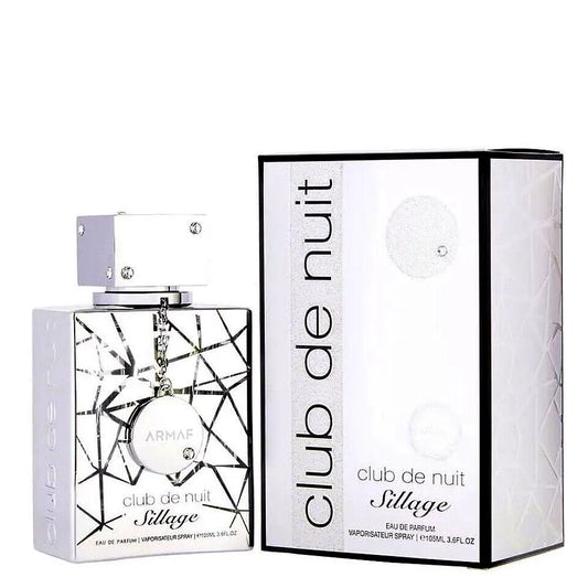 A sleek, modern bottle of Armaf Club de Nuit Sillage Eau de Parfum Mixte, featuring a silver cap and gradient blue glass design, resting on a minimalist background.